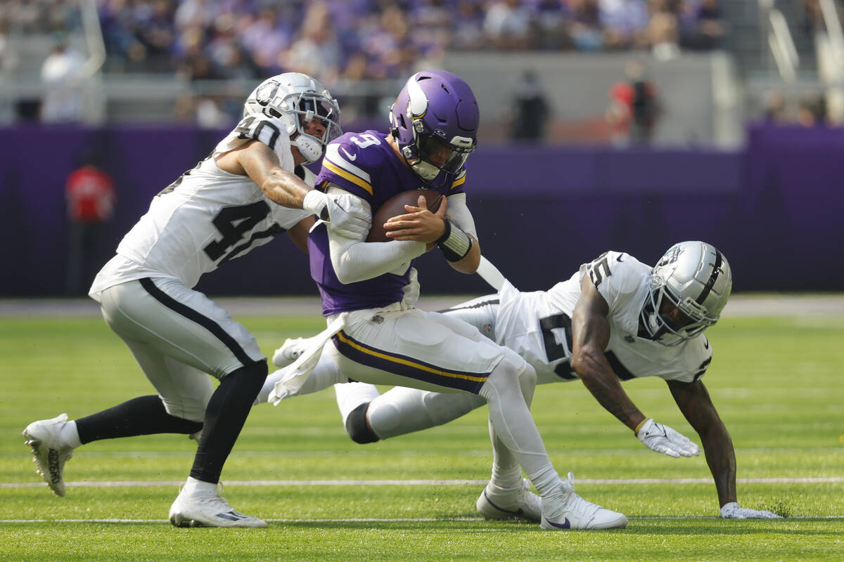 Minnesota Vikings quarterback J.J. McCarthy (9) is hit by Las Vegas Raiders safety Jaydon Grant ...