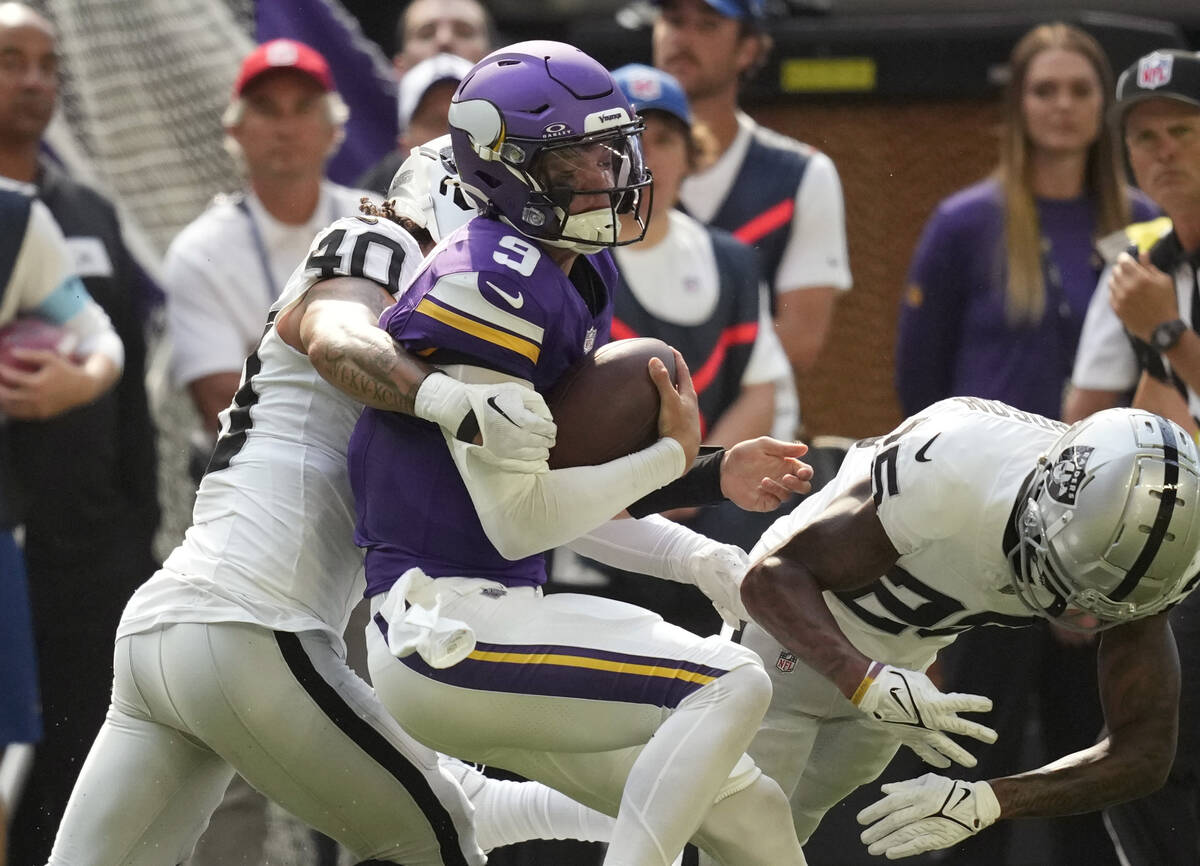 Minnesota Vikings quarterback J.J. McCarthy (9) is hit by Las Vegas Raiders safety Jaydon Grant ...