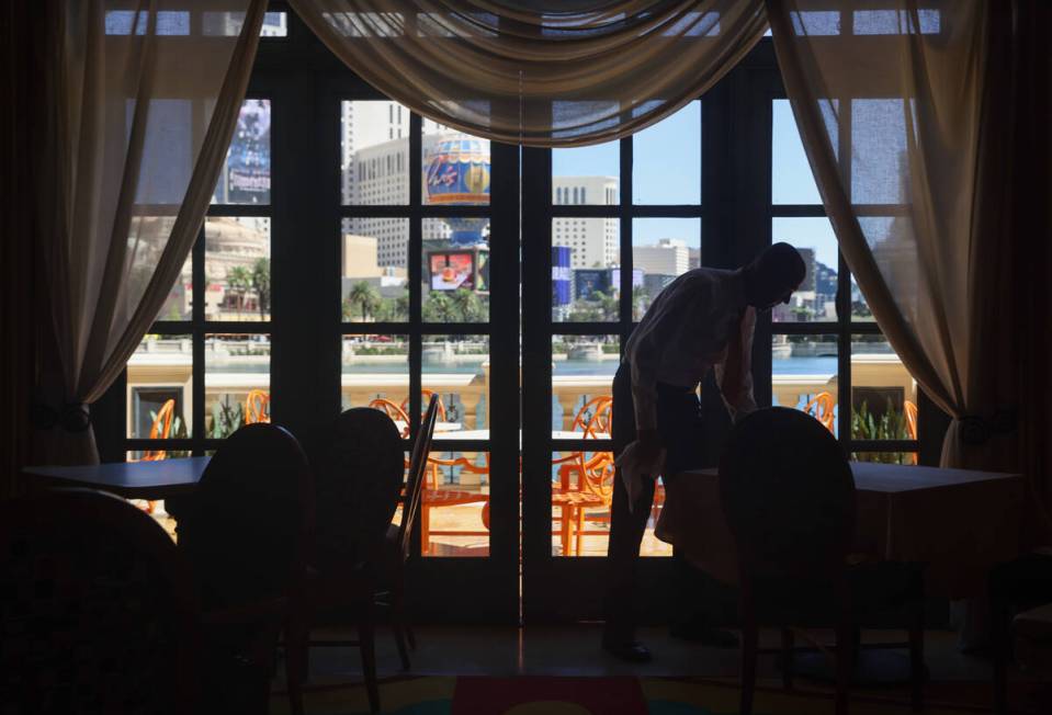 Server Ryland Worrell prepares a table for dinner service at Picasso at the Bellagio hotel-casi ...