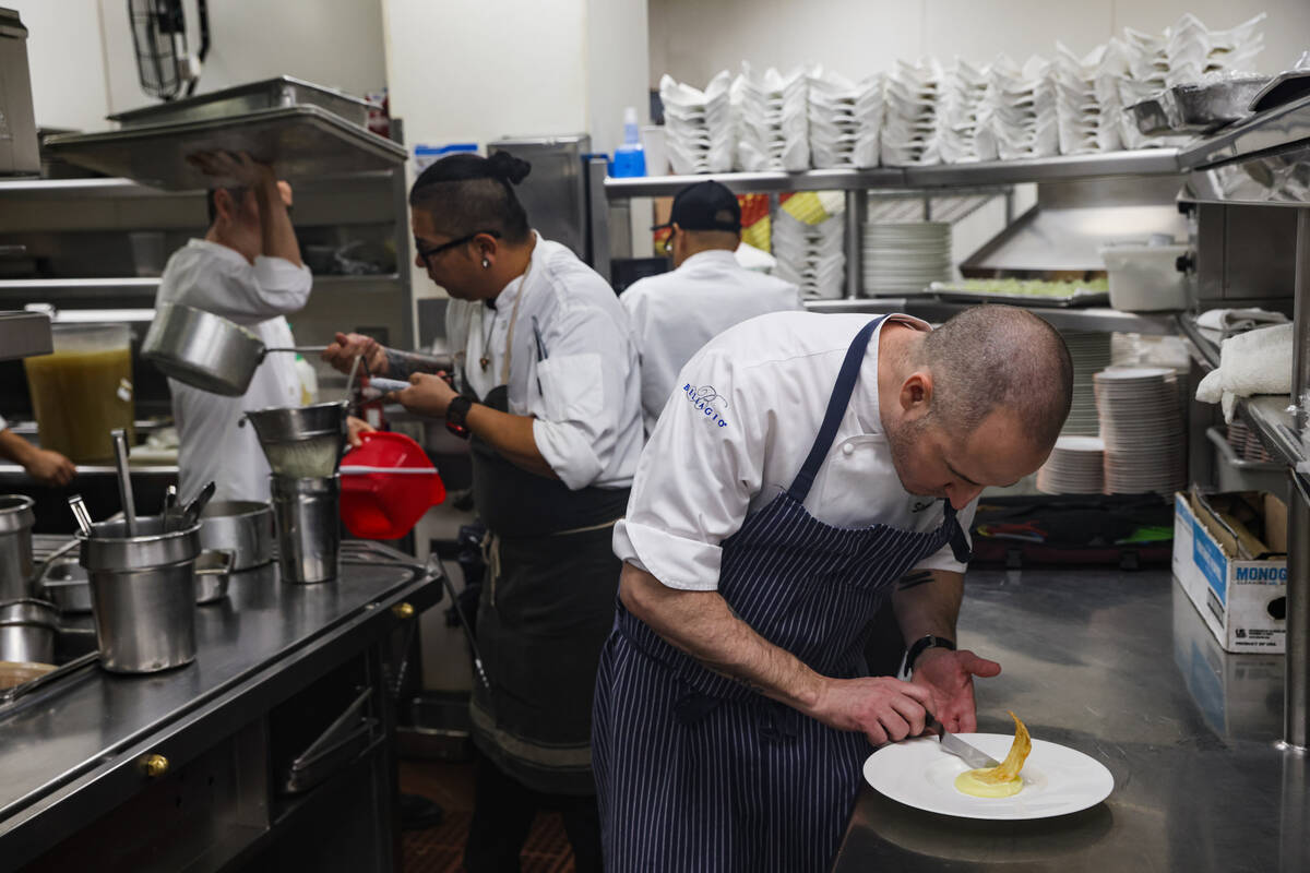 Chef Stephen Johnson prepares pan seared U-10 day boat scallop in the kitchen at Picasso at the ...