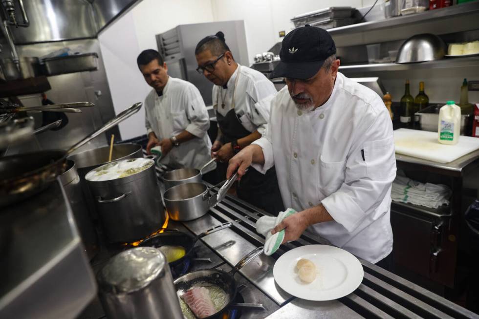 Master cook Alvino Gomez sears a fish in the kitchen at Picasso at the Bellagio hotel-casino in ...