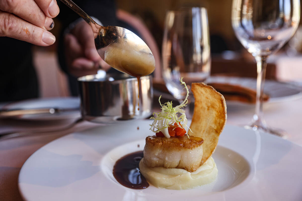 Chef Julian Serrano spoons out jus de veau on the pan seared U-10 day boat scallop at Picasso a ...