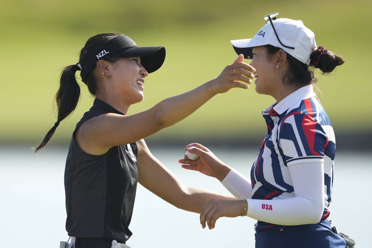 Lydia Ko, of New Zealand, left winner of the gold medal embraces Rose Zhang, of the United Stat ...