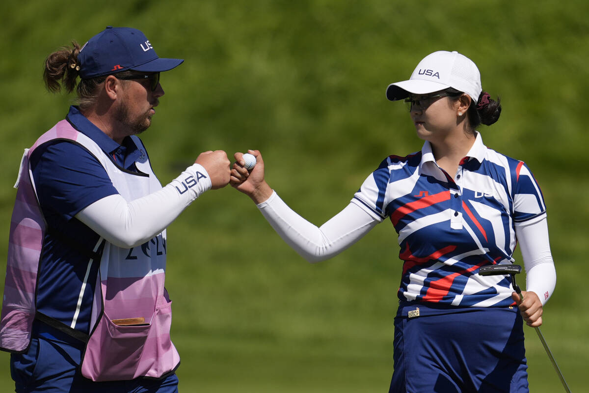 Rose Zhang, of the United States, bumps fists with her caddie after a birdie putt on the 11th g ...