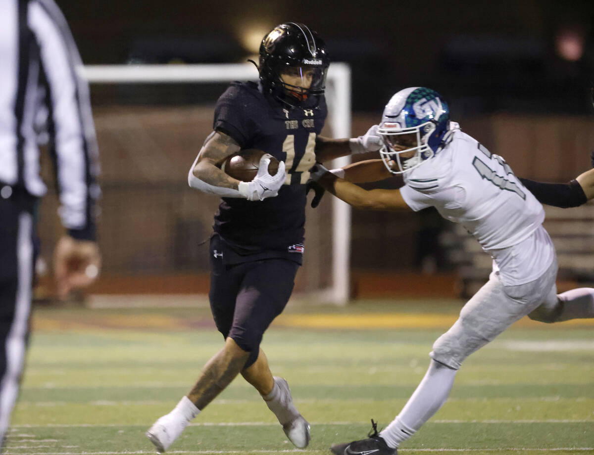 Faith Lutheran's running back Cale Breslin (14) avoids a tackle from Green Valley's defensive b ...