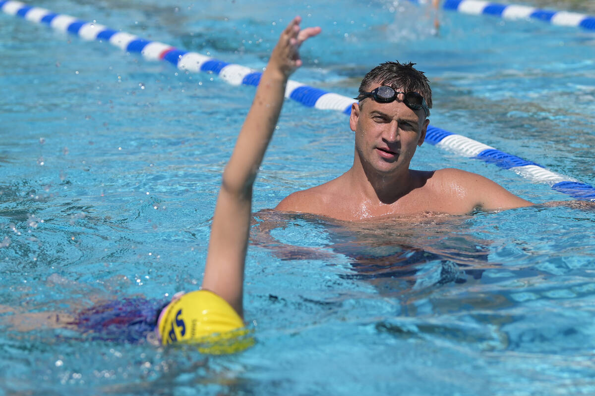 Current world record holder and 12-time Olympic medalist Ryan Lochte assesses a participant dur ...