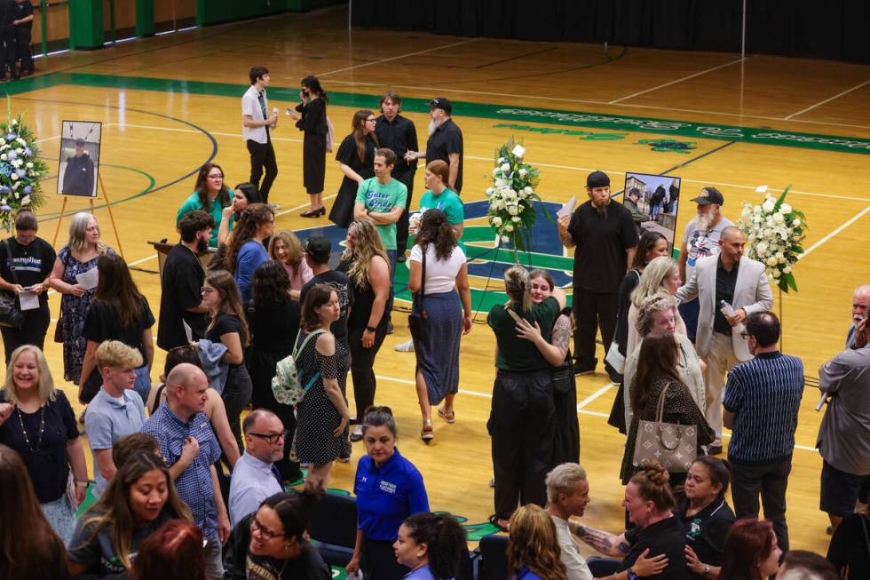 Friends, family and students congregate following a memorial service for Eric Johnston, a forme ...