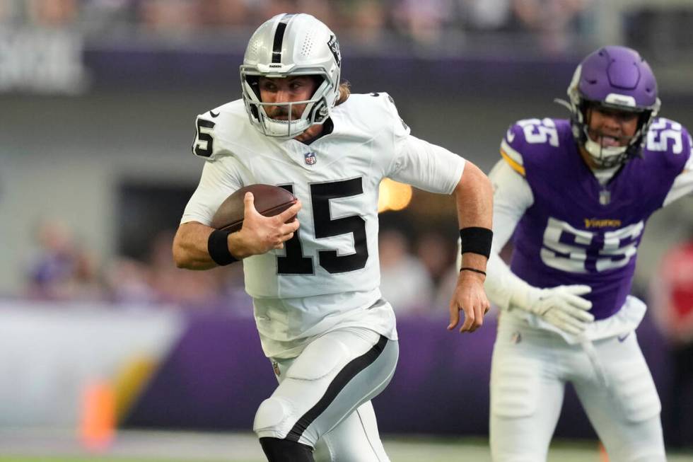 Las Vegas Raiders quarterback Gardner Minshew II (15) scramble past Minnesota Vikings linebacke ...