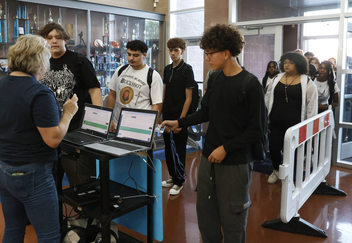 Legacy High School students line up to scan their badges during the first day of school on Mond ...