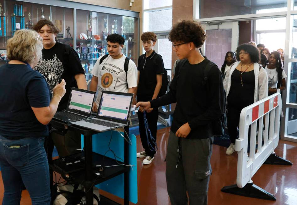 Legacy High School students line up to scan their badges during the first day of school on Mond ...