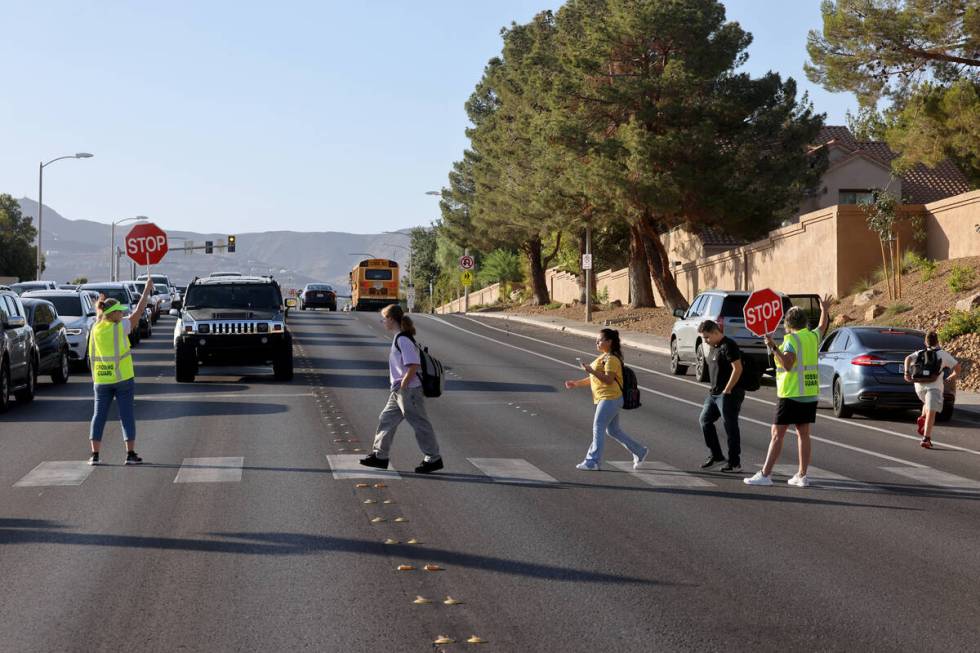 Crossing guards Sonja Castleman, left, and Cindy Branby help students get across the street on ...