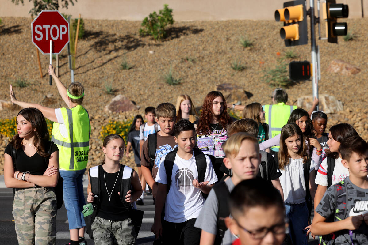 Crossing guards Sonja Castleman, left, and Cindy Branby help students get across the street on ...