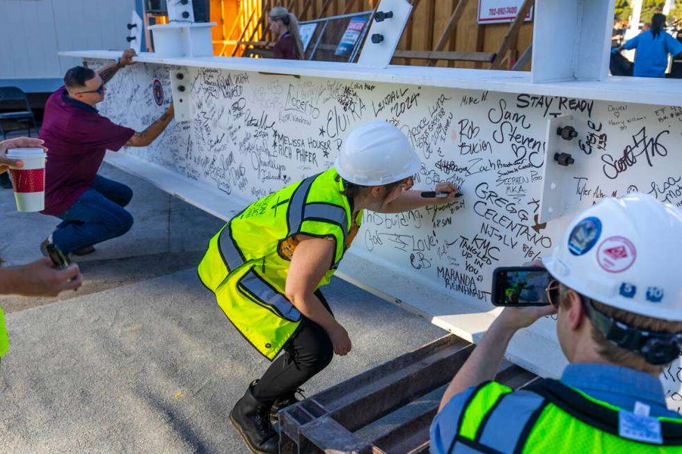 Workers sign the beam as the Las Vegas Convention and Visitors Authority holds a topping-off ce ...