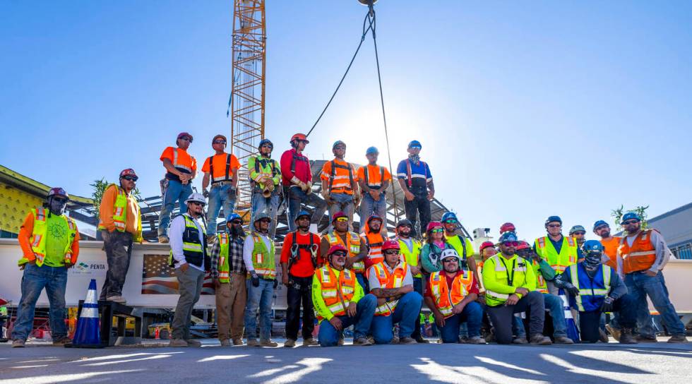 Workers pose for a group photo as the Las Vegas Convention and Visitors Authority holds a toppi ...