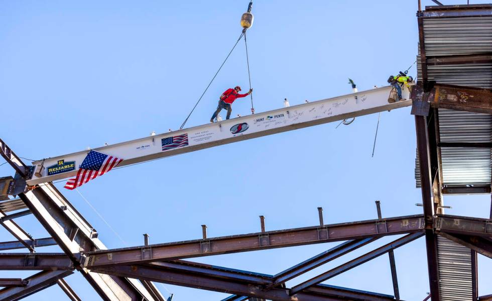 Workers secure the beam into place as the Las Vegas Convention and Visitors Authority holds a t ...