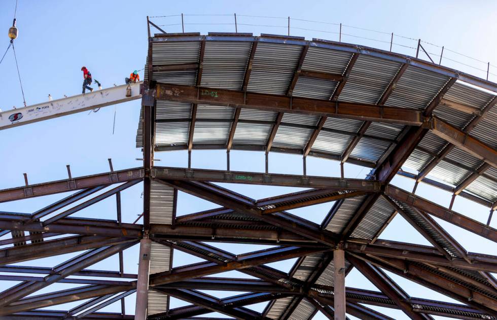 Workers secure the beam into place as the Las Vegas Convention and Visitors Authority holds a t ...