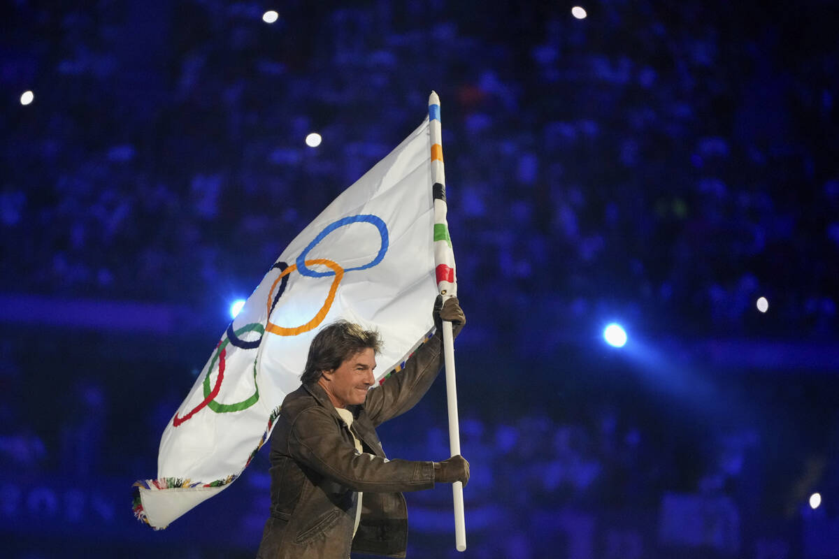 Tom Cruise carries the Olympic flag during the 2024 Summer Olympics closing ceremony at the Sta ...