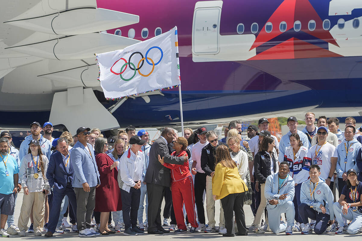 Los Angeles Mayor Karen Bass, hugs Inglewood James Butts, middle, as they pose for a picture wi ...