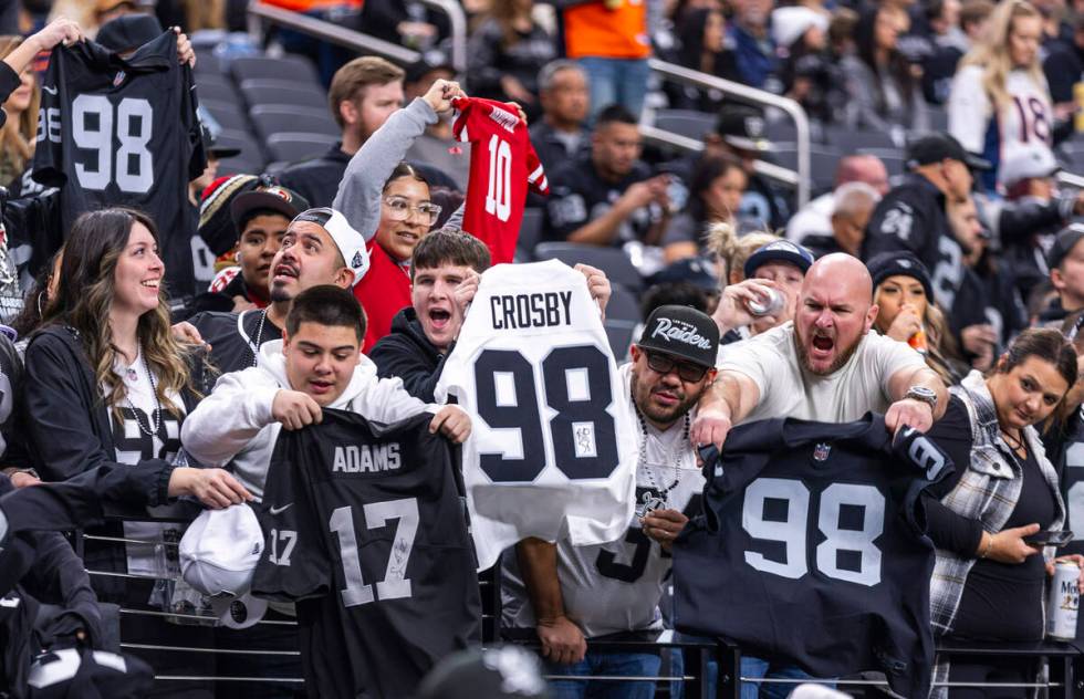 Raiders defensive end Maxx Crosby (98) and wide receiver Davante Adams (17) fans wave their jer ...