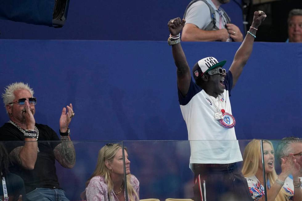 Guy Fieri, left, and Flavor Flav, stand, cheer during a women's water polo Group B preliminary ...