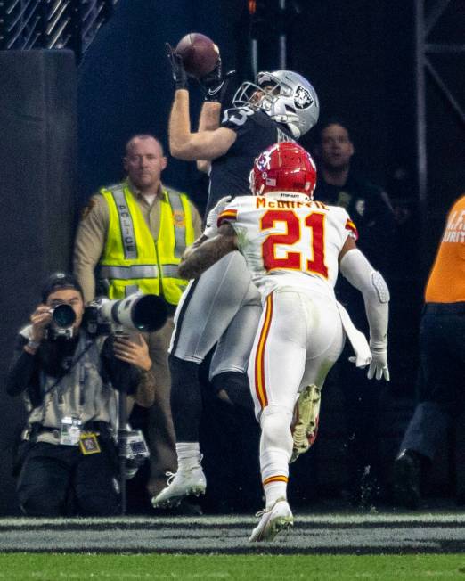 A Metro officer in a yellow vest is seen in the background as Raiders wide receiver Hunter Renf ...