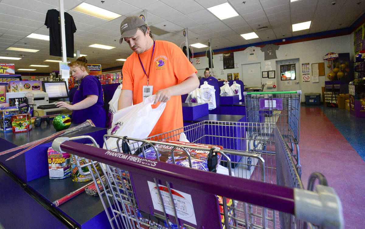 FILE - James Pratt, head cashier at Phantom Fireworks in Hinsdale, N.H., helps bag a customer's ...