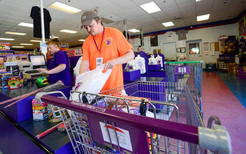 FILE - James Pratt, head cashier at Phantom Fireworks in Hinsdale, N.H., helps bag a customer's ...