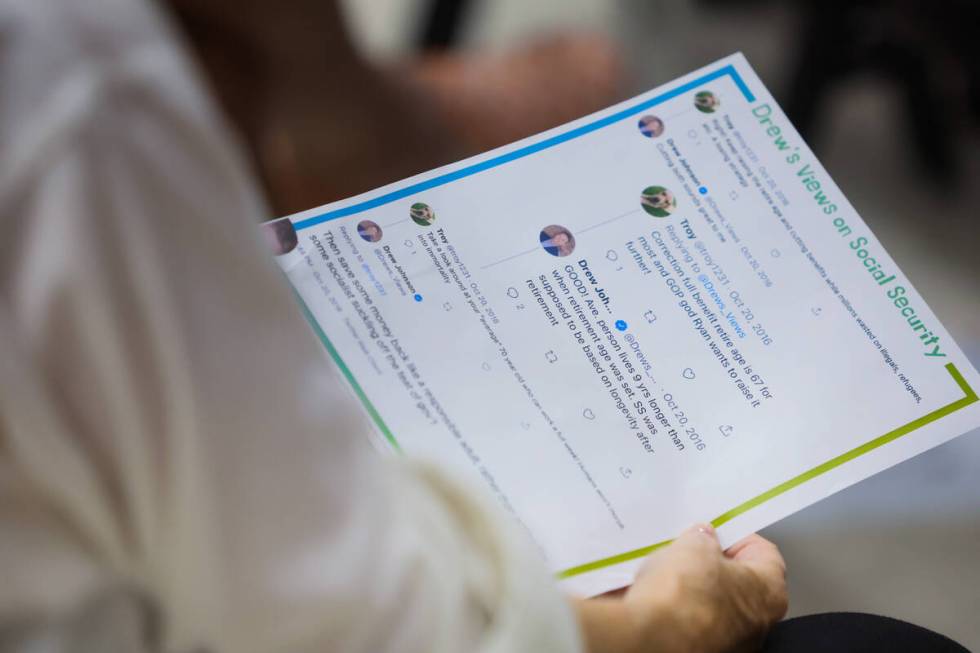 An attendee holds a piece of paper that was handed out of GOP congressional candidate Drew John ...