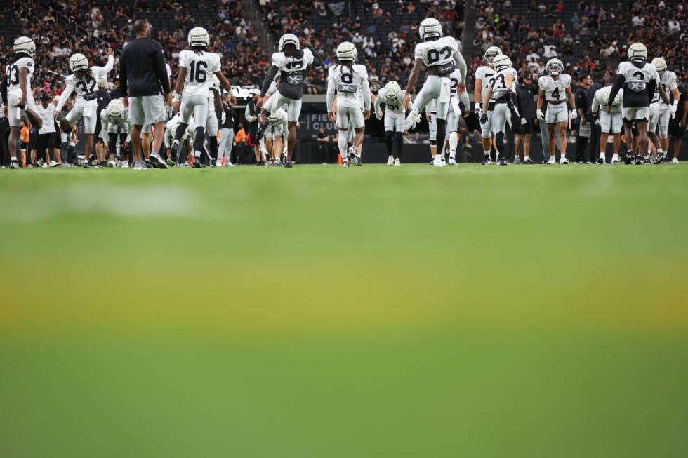 The Raiders stretch during an NFL football practice at Allegiant Stadium on Wednesday, Aug. 14, ...