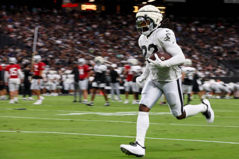 Raiders running back Alexander Mattison (22) takes the ball up the field during an NFL football ...