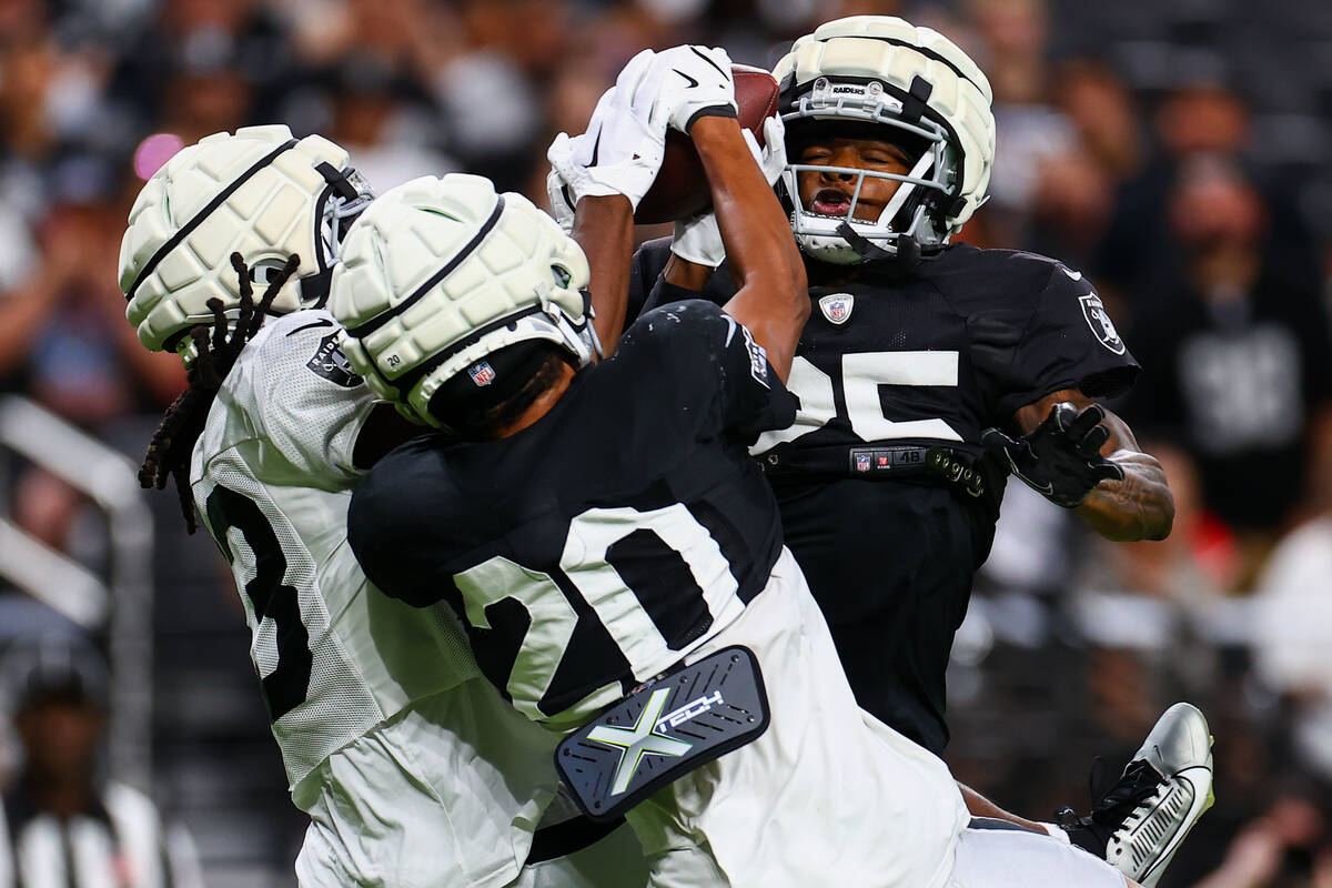 Raiders wide receiver Kristian Wilkerson, left, fights for a touchdown pass with pressure from ...