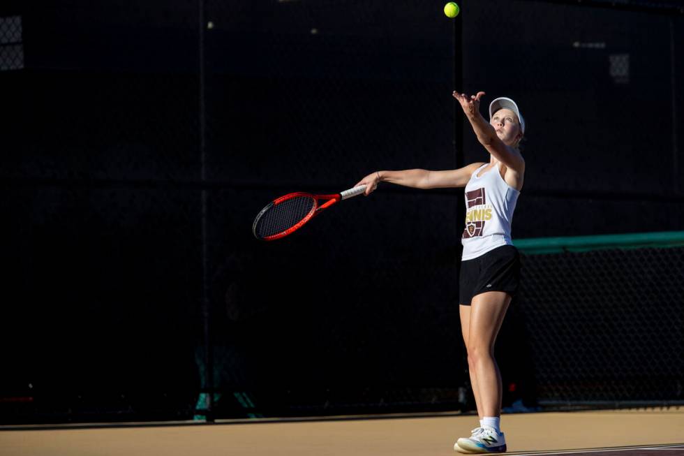 Faith Lutheran sophomore McCauley Hill serves the ball during the tennis matches against The Me ...