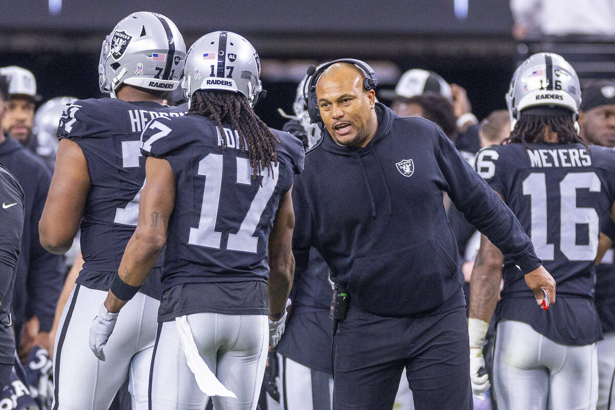 Raiders interim Head Coach Antonio Pierce chats with wide receiver Davante Adams (17) against t ...