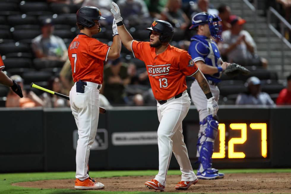 Las Vegas Aviators infielder Jordan Diaz high-fives infielder Max Muncy (7) after hitting a hom ...