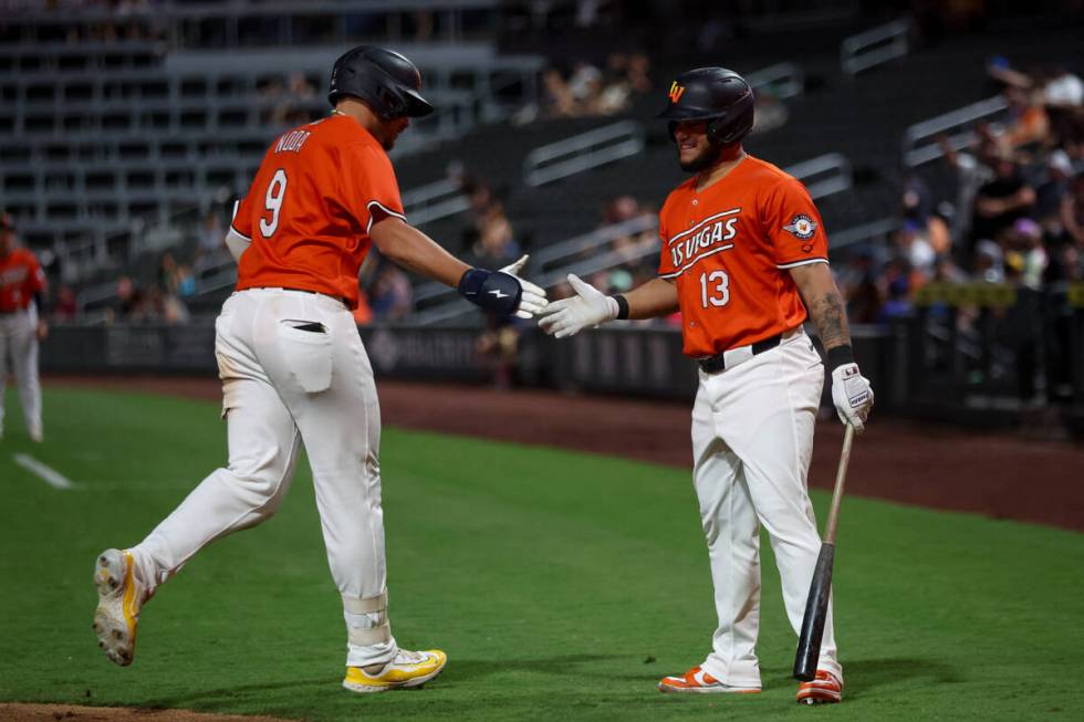 Las Vegas Aviators infielder Ryan Noda (9) high-fives infielder Jordan Diaz (13) after scoring ...