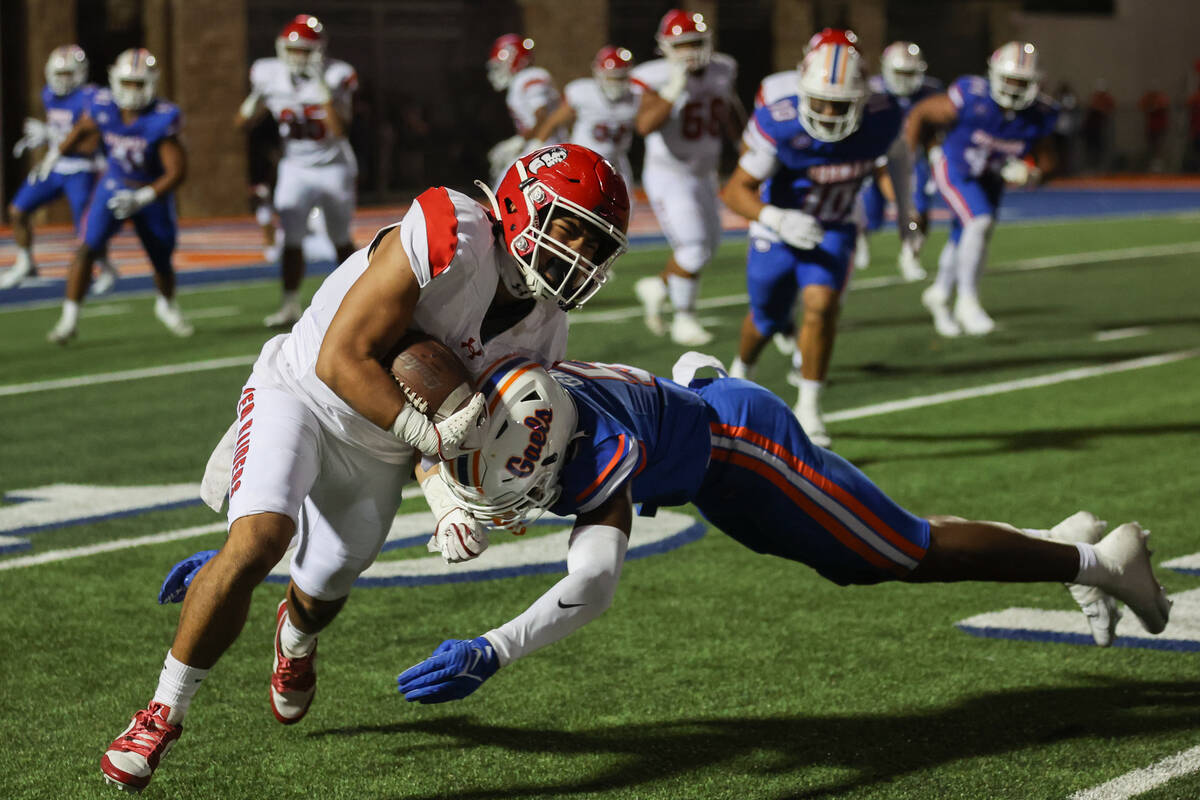 Bishop Gorman wide receiver Jett Washington (5) tackles Kahuku running back Isaiah Joaquin (34) ...