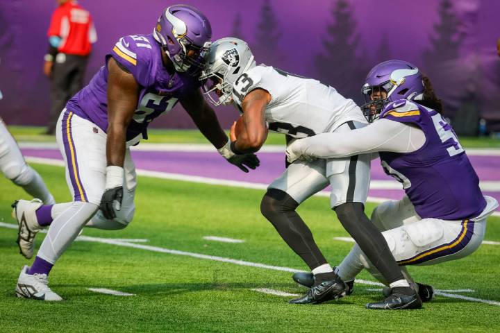 Minnesota Vikings defensive lineman Eric Rodriguez, right, sacks Las Vegas Raiders quarterback ...