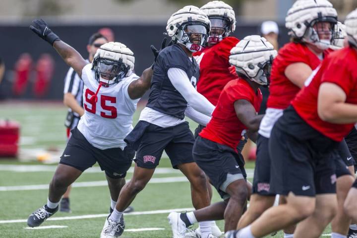 UNLV defensive lineman Alexander Whitmore (95) attempts to stop quarterback Hajj-Malik Williams ...