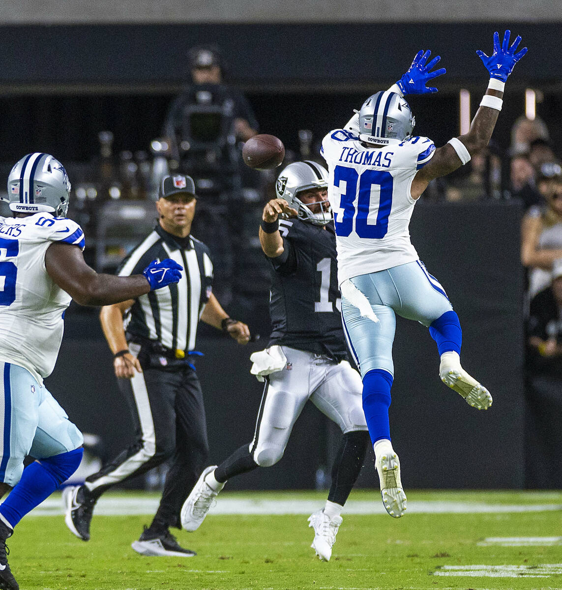 Raiders quarterback Gardner Minshew (15) slings the ball around Dallas Cowboys safety Juanyeh T ...