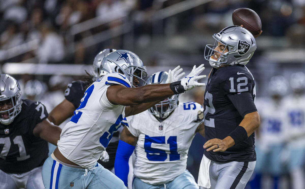 Raiders quarterback Aidan O'Connell (12) attempts to get the ball off on a big rush from Dallas ...