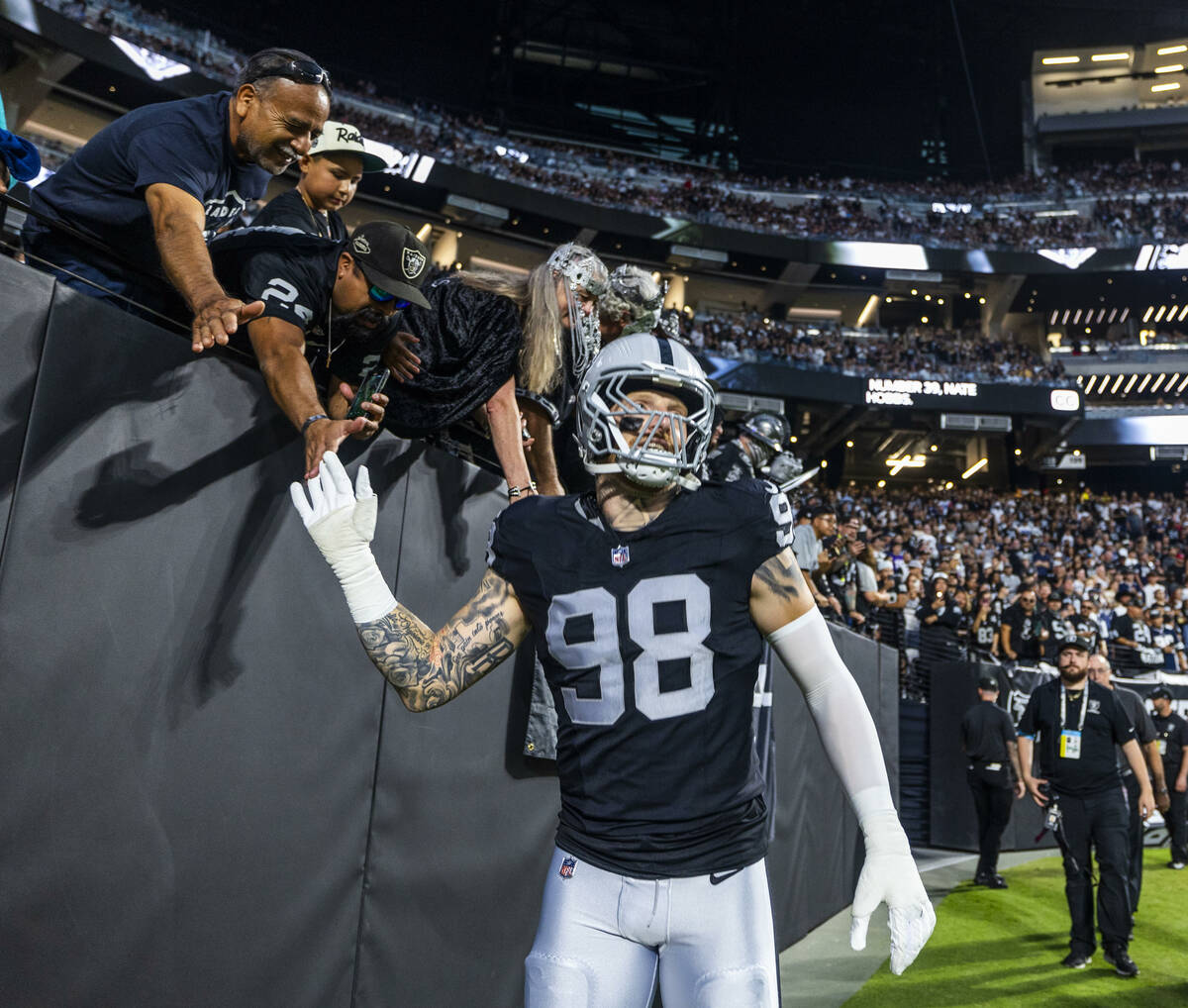 Raiders defensive end Maxx Crosby (98) greets fans as he takes the field against the Dallas Cow ...