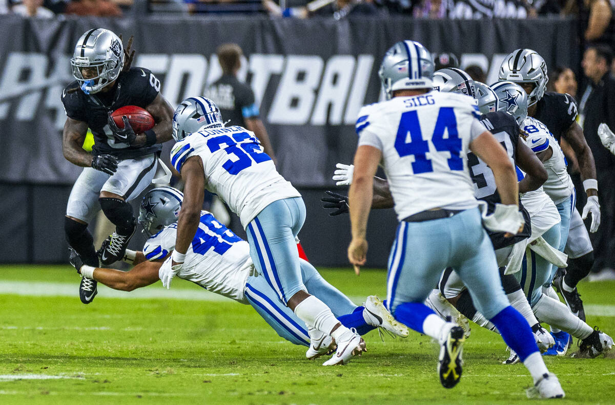 Raiders running back Ameer Abdullah (8) leaps on a return while wrapped up by Dallas Cowboys ti ...