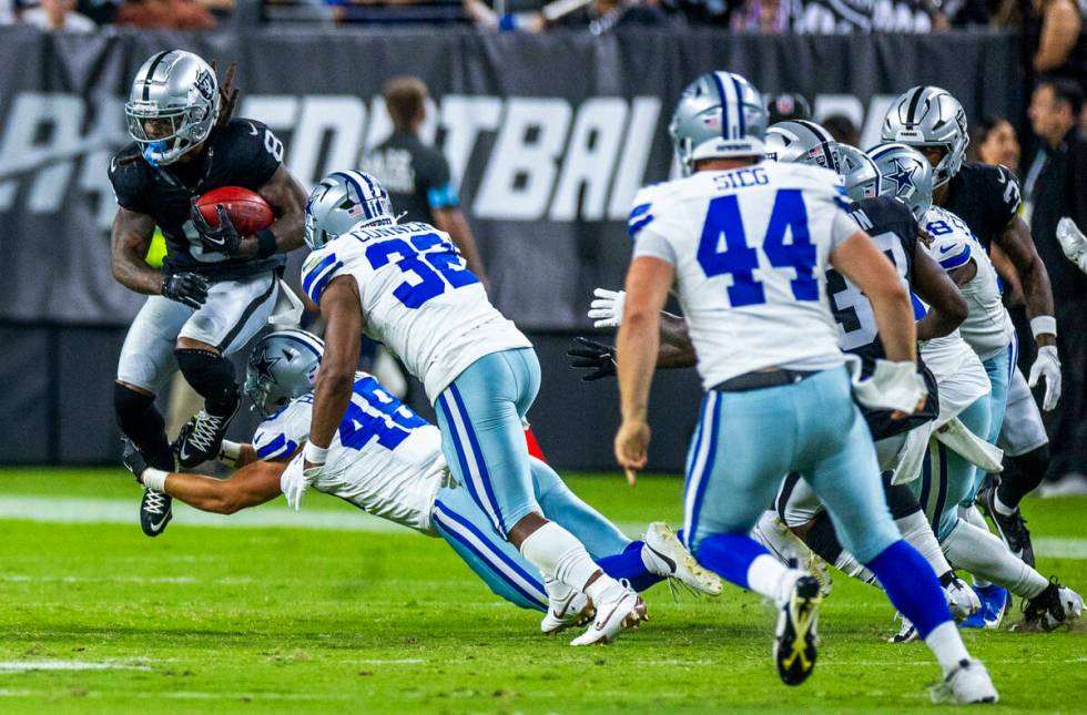 Raiders running back Ameer Abdullah (8) leaps on a return while wrapped up by Dallas Cowboys ti ...