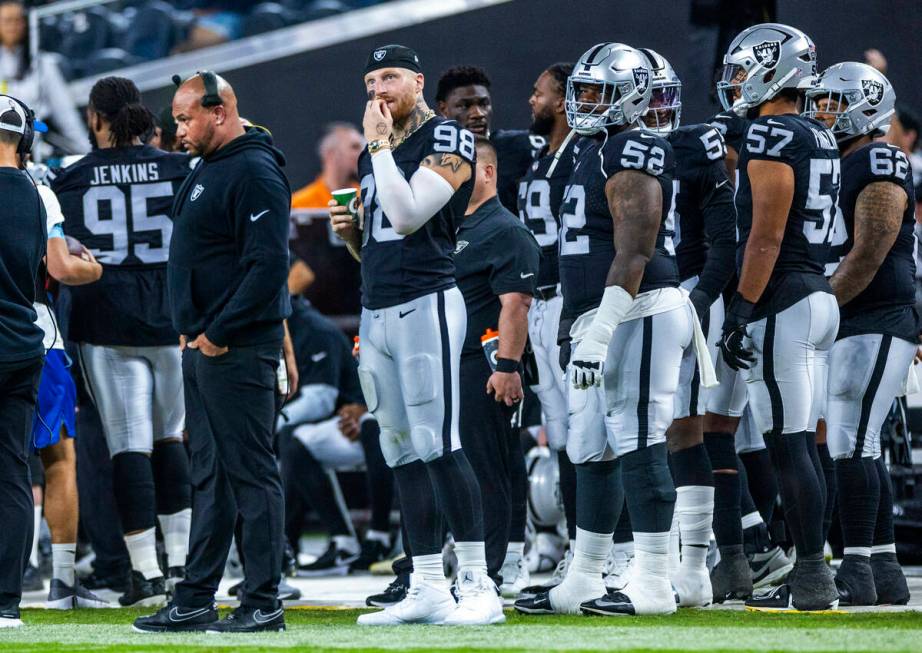 Raiders head coach Antonio Pierce appears dismayed as defensive end Maxx Crosby (98) chews his ...