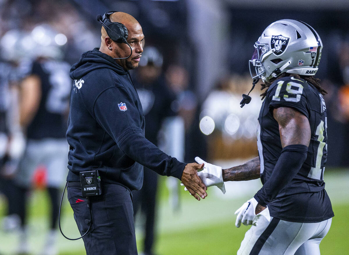 Raiders head coach Antonio Pierce greets Raiders wide receiver DJ Turner (19) on the sidelines ...