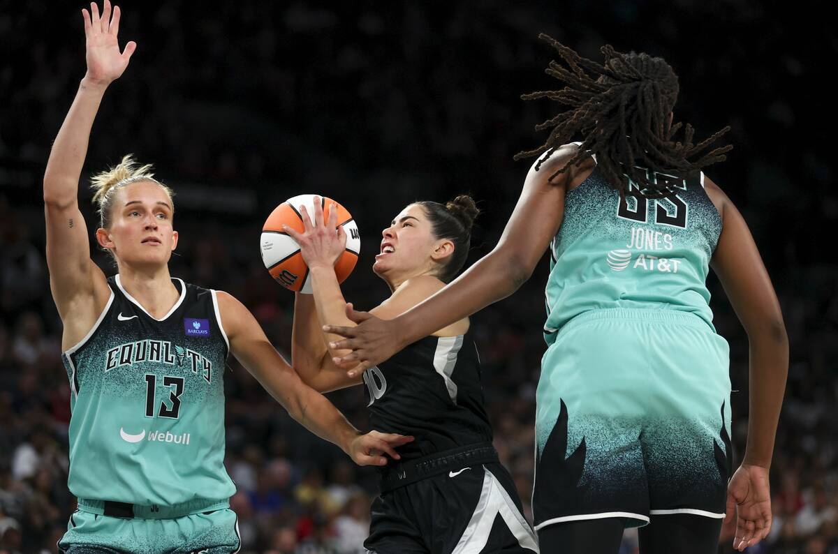 Las Vegas Aces guard Kelsey Plum (10) drives toward the hoop between New York Liberty forward L ...