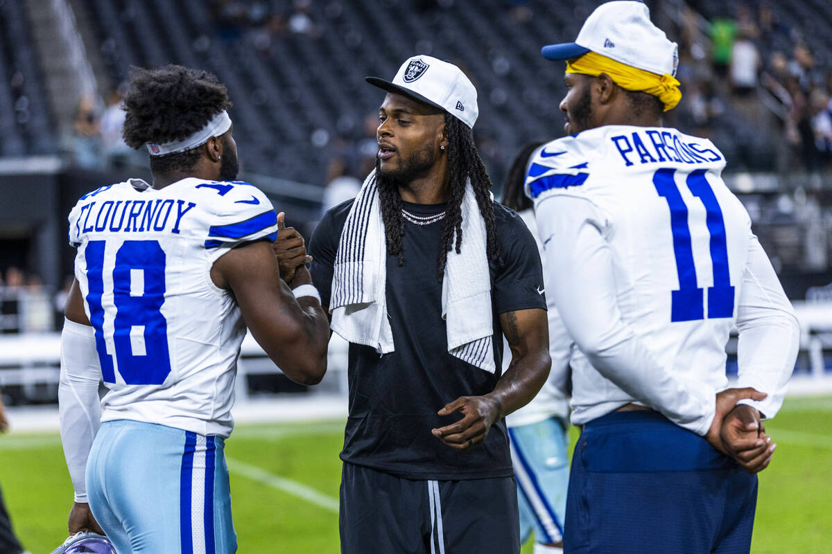 Raiders wide receiver Davante Adams (17) chats with Dallas Cowboys linebacker Micah Parsons (11 ...