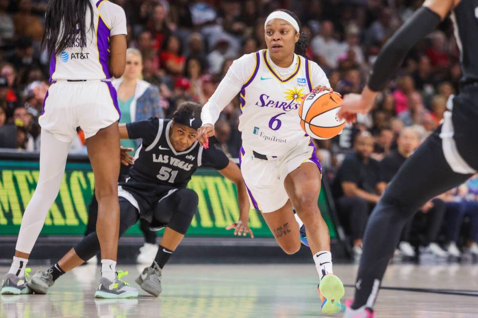 Aces guard Sydney Colson (51) falls as she chases LA Sparks guard Odyssey Sims (6) during a WNB ...