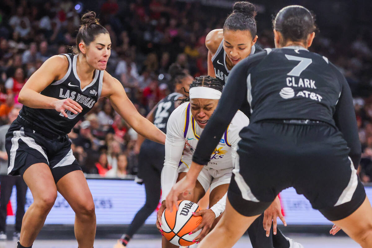 LA Sparks guard Odyssey Sims (6) fights to keep hold of the ball as Aces defense surrounds her ...