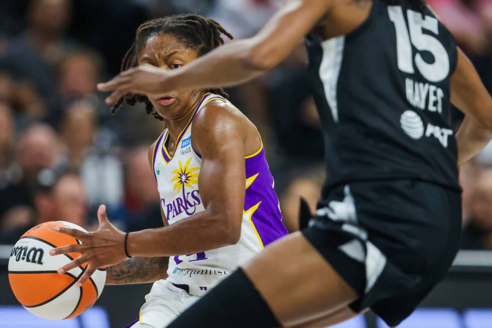 Los Angeles Sparks guard Aari McDonald (15) struggles to move the ball past Aces guard Tiffany ...